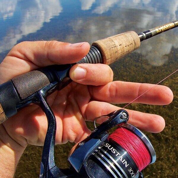 Red braided fishing line in shallow grass